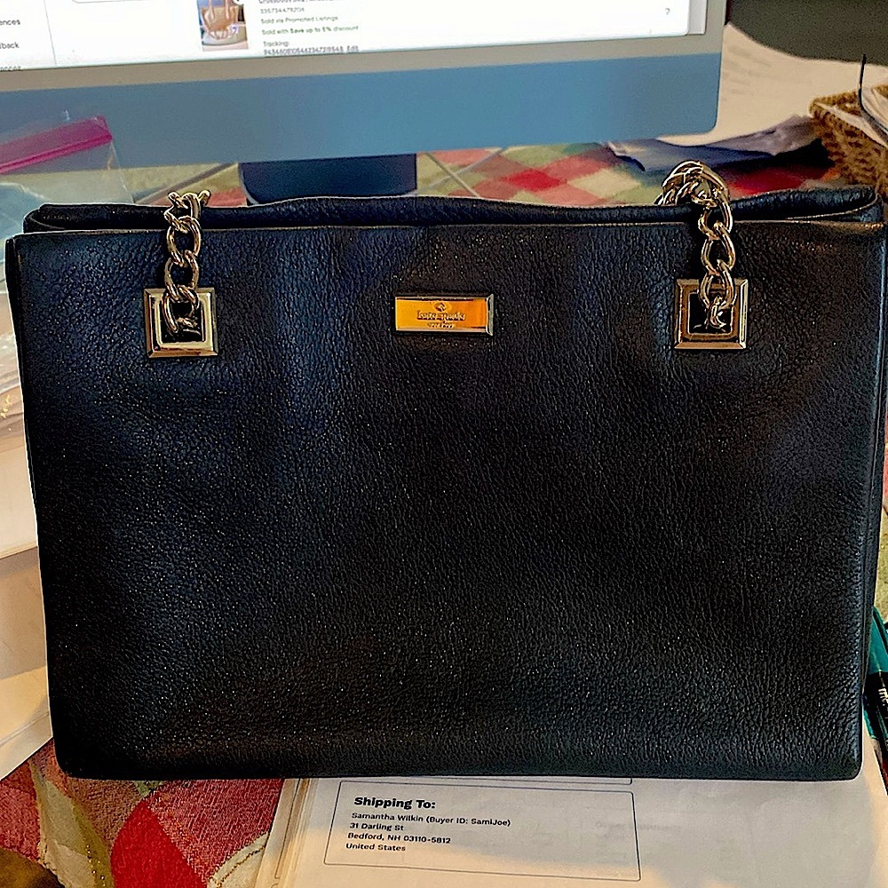 Black leather Kate Spade handbag with gold chain shoulder straps.